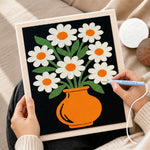 Creating handmade daisy flowers in orange vase punch needle artwork