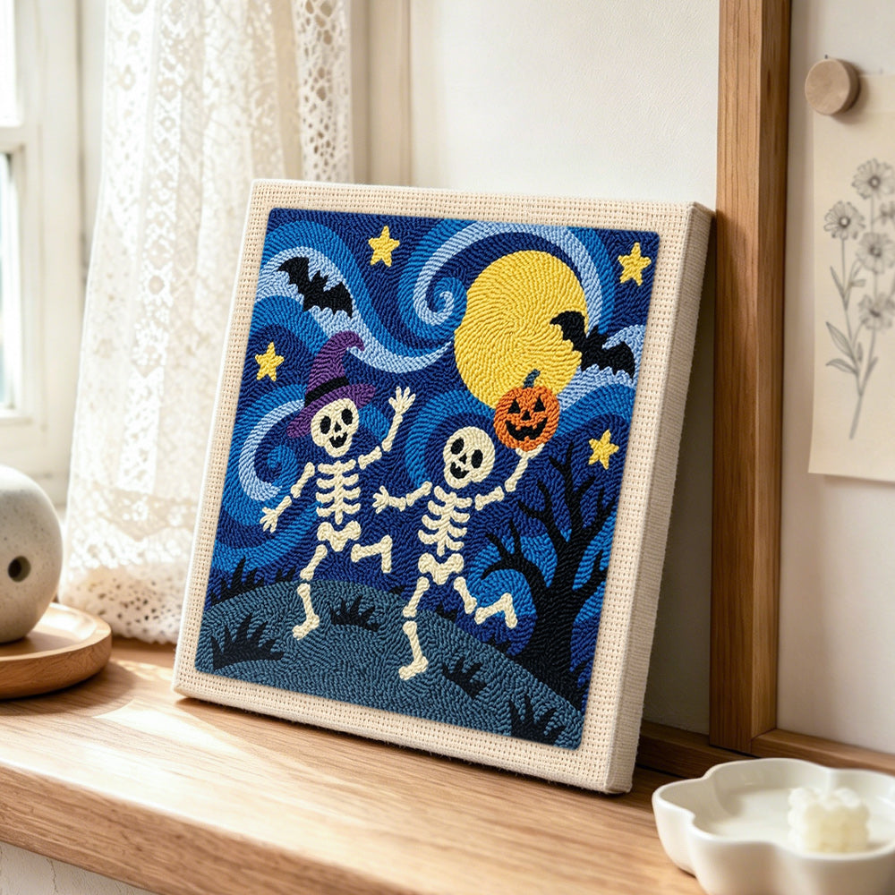 Dancing skeletons under moon punch needle artwork displayed on a table