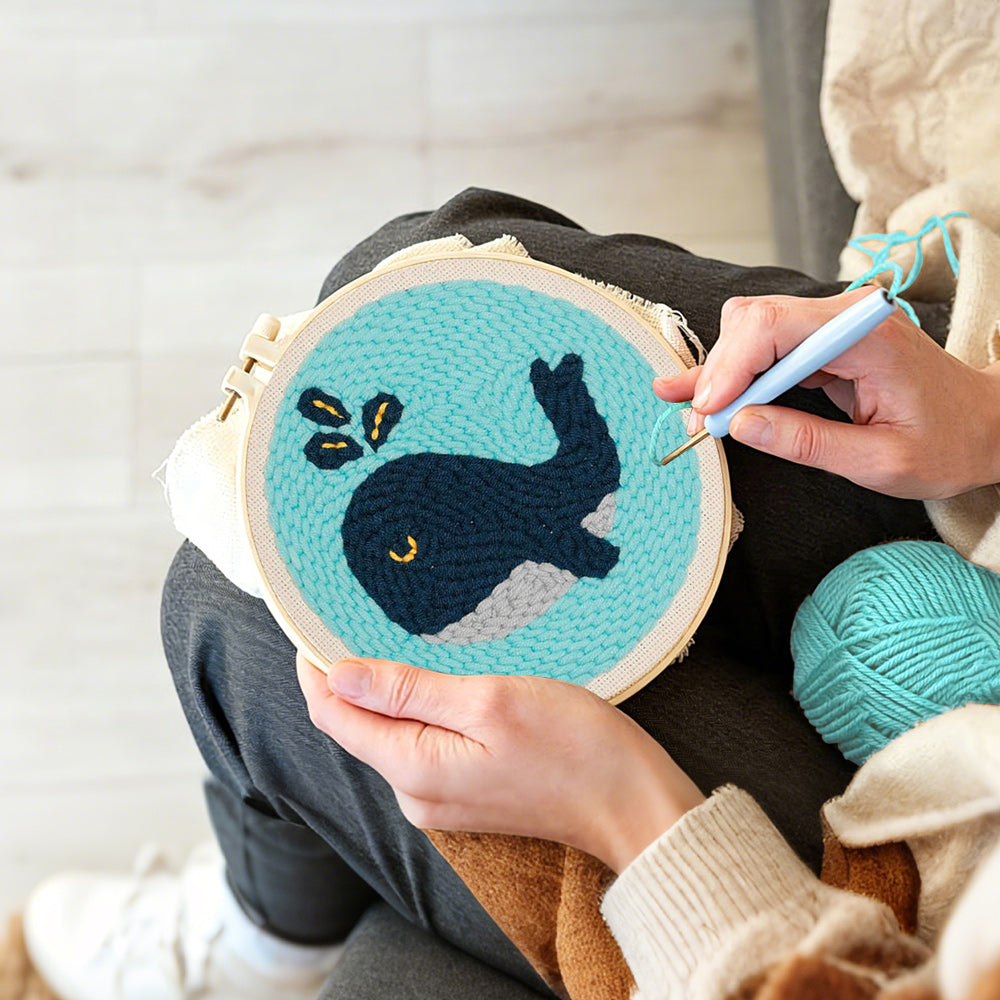 Creating handmade dark blue whale punch needle artwork