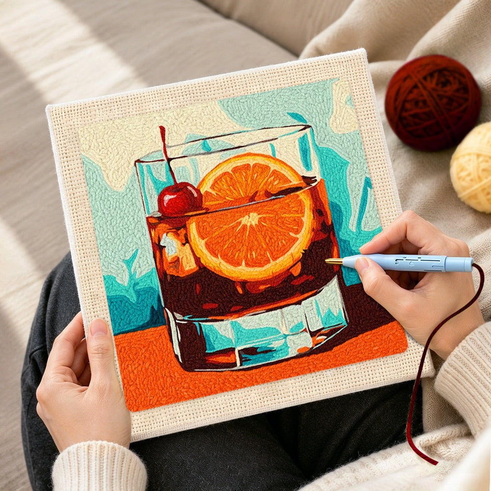 Creating handmade dark cocktail with cherry and orange punch needle artwork