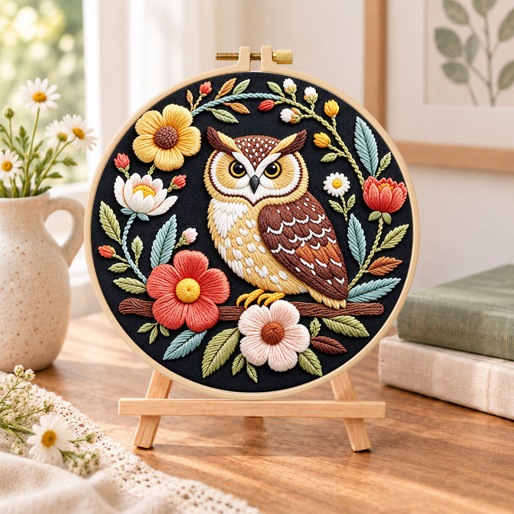 Dark floral owl embroidery kit finished hoop displayed on a wooden stand as cozy tabletop decor