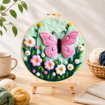 Finished delicate pink butterfly and flowers needle felting displayed on a wooden easel