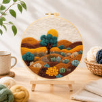 Finished desert landscape with succulents needle felting displayed on a wooden easel