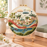 Desert stream hamlet embroidery kit finished hoop displayed on a wooden stand as cozy tabletop decor