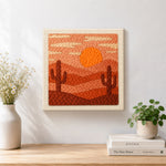Finished desert sunset and cacti artwork displayed on a wall