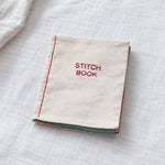 Closed DIY embroidery stitch practice book with an embroidered fabric cover and layered fabric pages