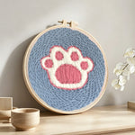 Dog paw print punch needle artwork displayed on a table