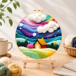 Finished dreamy cottage under the rainbow aurora needle felting displayed on a wooden easel