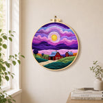 Dreamy swirling purple sky and red barn needle felt wall art displayed in a bright home interior