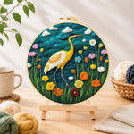 Finished elegant yellow heron among flowers needle felting displayed on a wooden easel