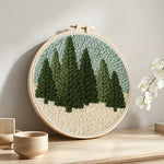 Evergreen forest punch needle artwork displayed on a table