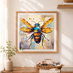 Finished expressive splatter paint bee cross stitch artwork displayed as home decor