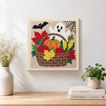 Finished fall harvest basket artwork displayed on a wall