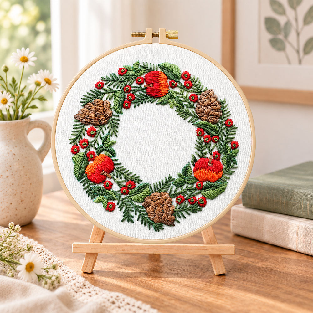 Festive fruit wreath embroidery kit finished hoop displayed on a wooden stand as cozy tabletop decor