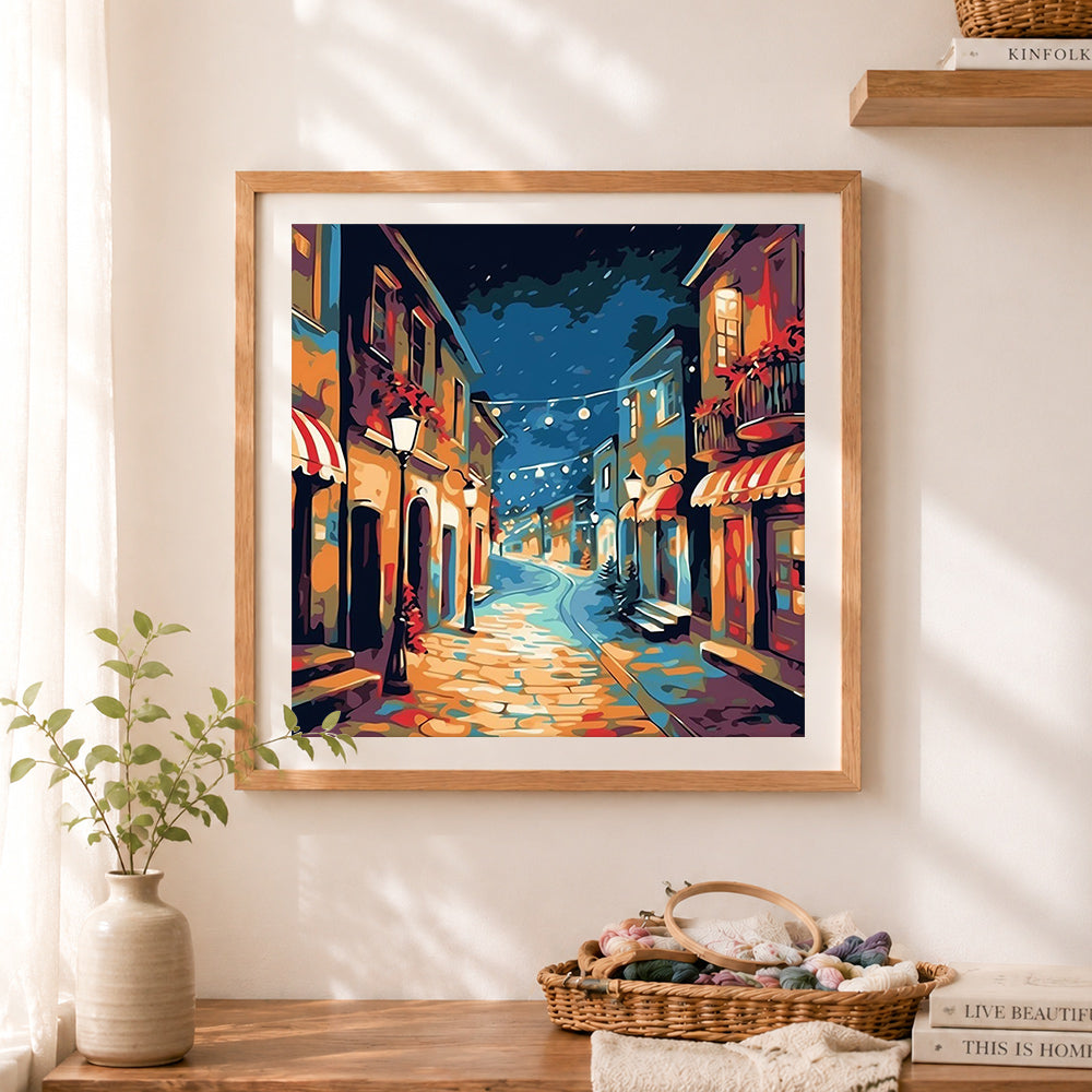 Finished festive night european town street cross stitch artwork displayed as home decor