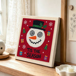 Festive snowman with gifts punch needle artwork displayed on a table