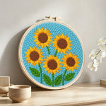Five sunflowers punch needle artwork displayed on a table