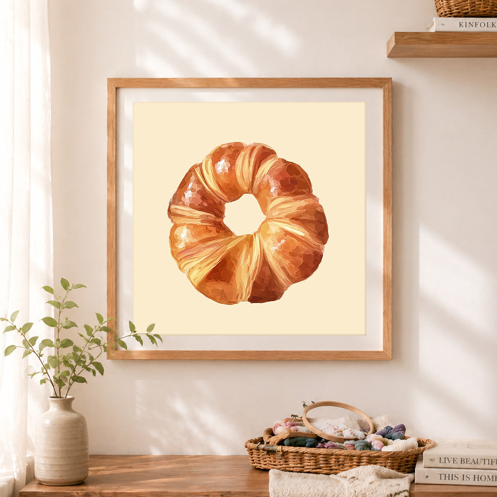 Finished flaky croissant cross stitch artwork displayed as home decor