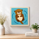 Finished floating happy otter artwork displayed on a wall