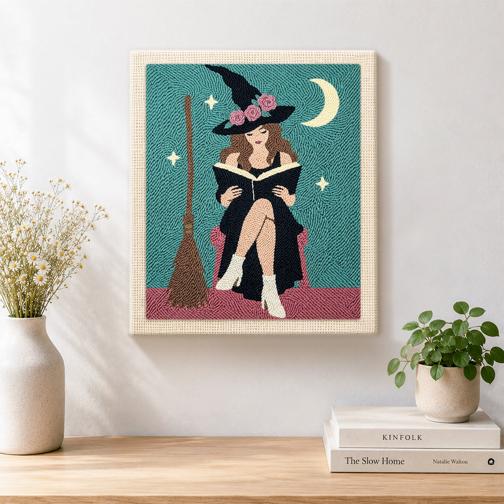 Finished floral‑hat witch reading book artwork displayed on a wall