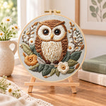 Floral owl portrait embroidery kit finished hoop displayed on a wooden stand as cozy tabletop decor