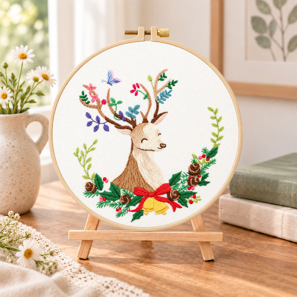 Floral reindeer art embroidery kit finished hoop displayed on a wooden stand as cozy tabletop decor