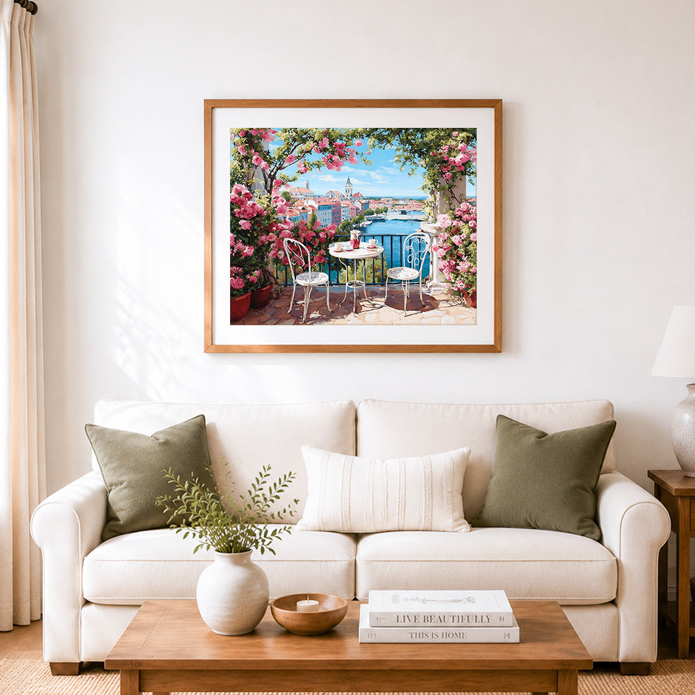 Finished floral seaside balcony cross stitch artwork displayed as home decor