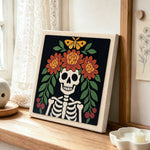 Floral skeleton punch needle artwork displayed on a table