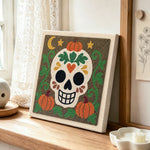 Floral sugar skull punch needle artwork displayed on a table