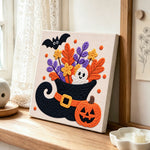 Floral witch hat ghost punch needle artwork displayed on a table