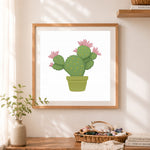 Finished flowering prickly pear cactus cross stitch artwork displayed as home decor