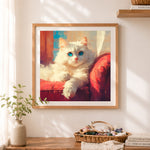 Finished fluffy white cat sofa cross stitch artwork displayed as home decor