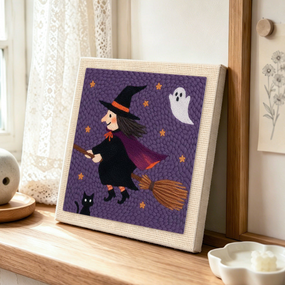 Flying witch on broom punch needle artwork displayed on a table