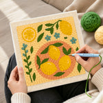 Creating handmade fresh lemons and little blue flowers punch needle artwork