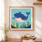 Finished friendly baby whale cross stitch artwork displayed as home decor
