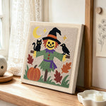 Friendly scarecrow punch needle artwork displayed on a table