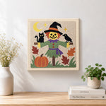 Finished friendly scarecrow artwork displayed on a wall