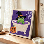 Frog bath time punch needle artwork displayed on a table