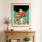 Finished frog on red mushroom cross stitch artwork displayed as home decor
