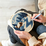 Creating handmade frozen blue forest and cosy cabin punch needle artwork