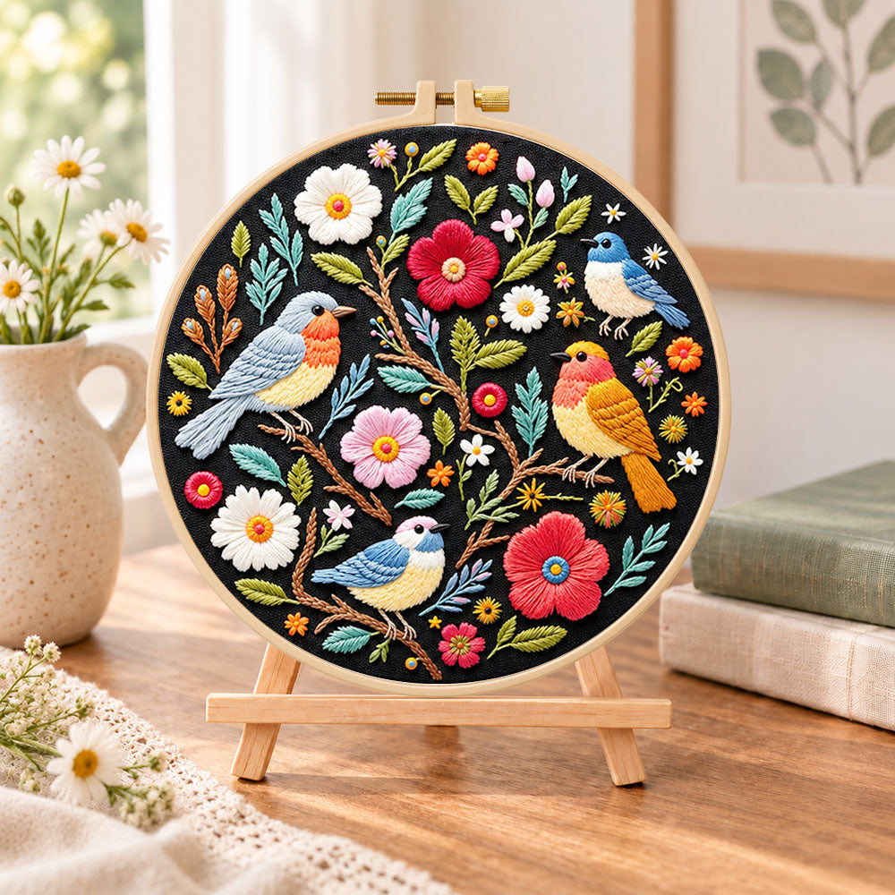 Garden birds and blossoms embroidery kit finished hoop displayed on a wooden stand as cozy tabletop decor