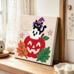 Ghost and black cat punch needle artwork displayed on a table
