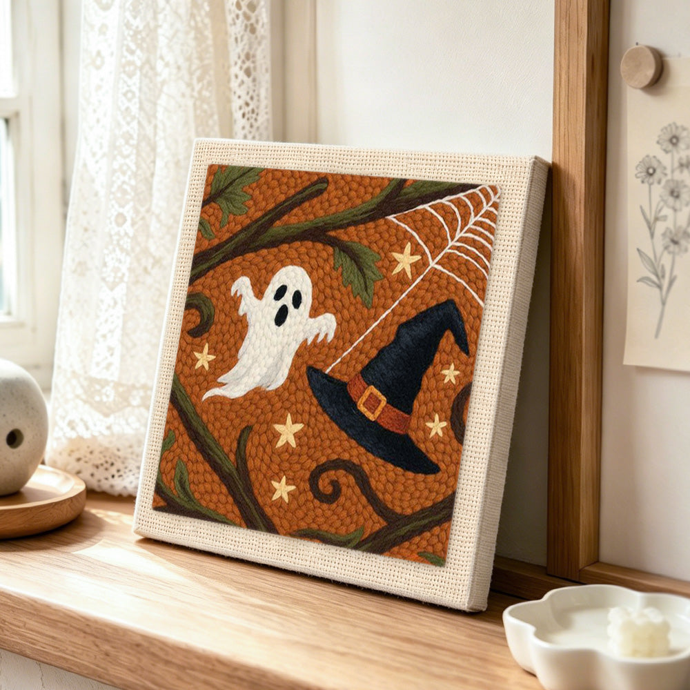 Ghost and witch hat punch needle artwork displayed on a table