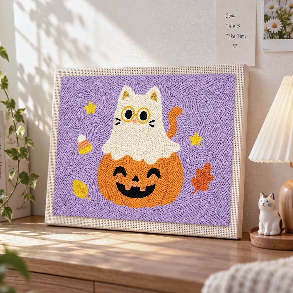 Ghost cat on pumpkin punch needle artwork displayed on a table