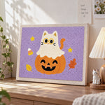 Ghost cat on pumpkin punch needle artwork displayed on a table