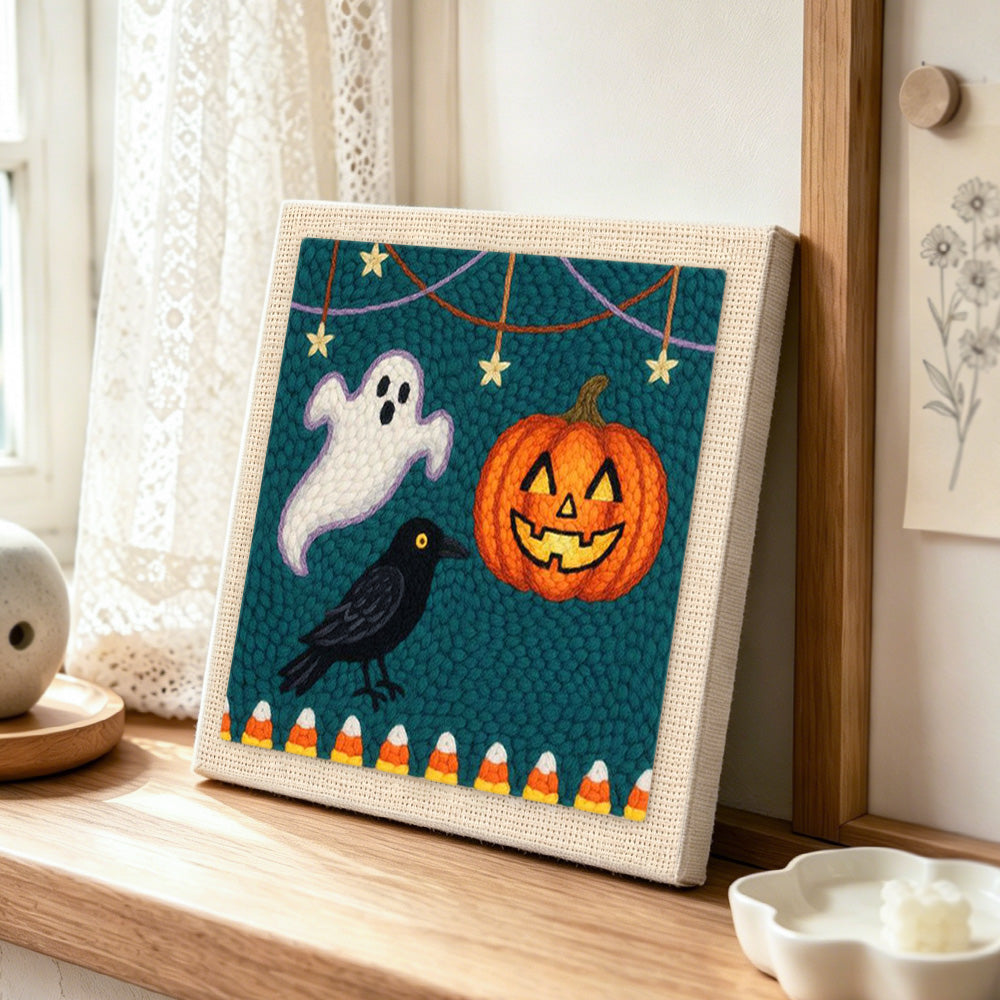 Ghost crow and pumpkin harvest punch needle artwork displayed on a table