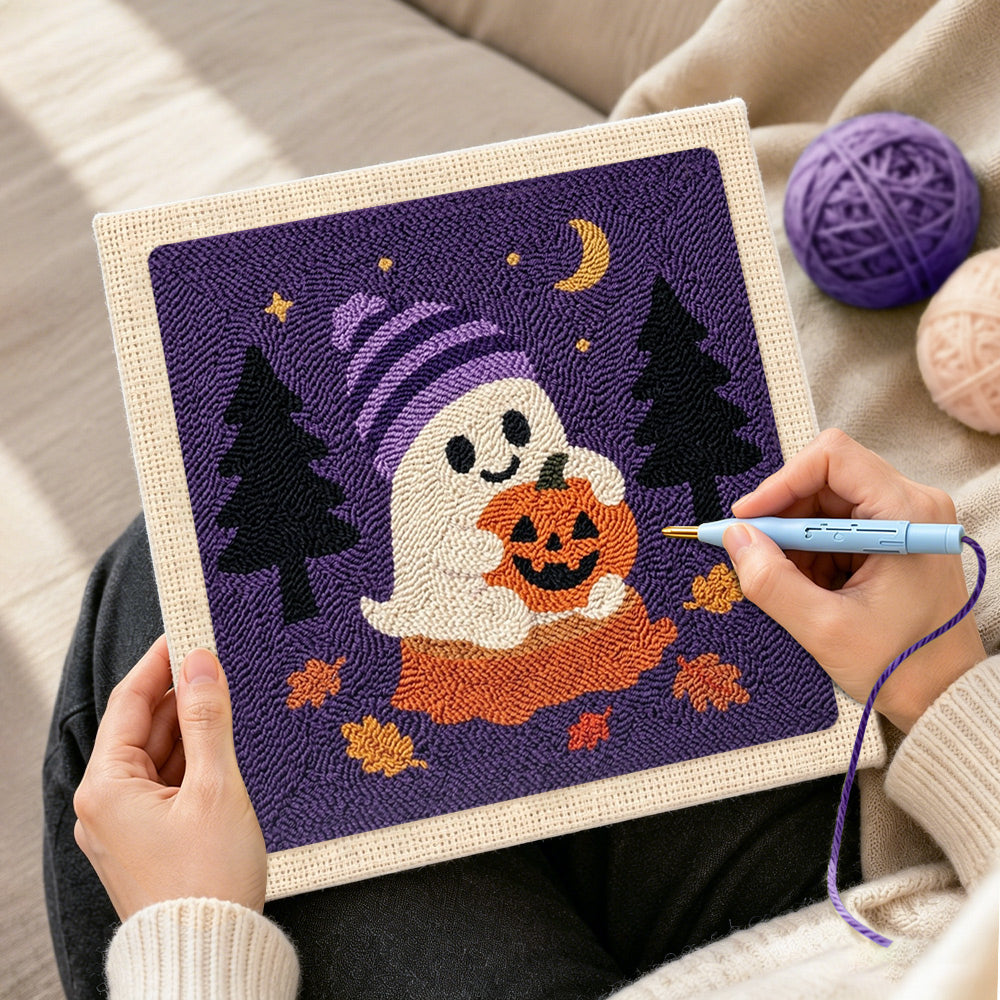 Creating handmade ghost holding pumpkin punch needle artwork