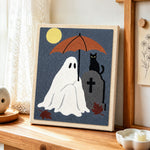 Ghost holding umbrella at graveyard punch needle artwork displayed on a table