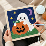 Creating handmade ghost hugging pumpkin punch needle artwork