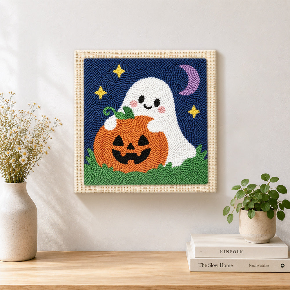 Finished ghost hugging pumpkin artwork displayed on a wall